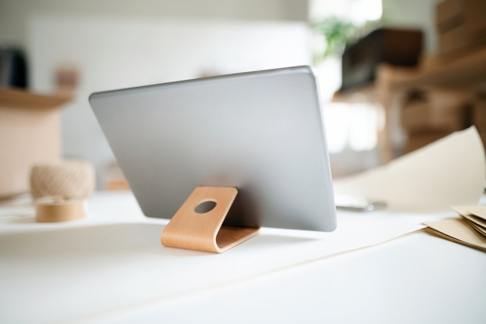 白いデスクの木製スタンドに立てたタブレット